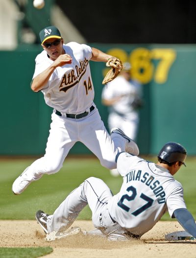 Oakland Athletics second baseman Mark Ellis completes a double-play throw over Seattle Mariners' Matt Tuiasosopo during the ninth inning Thursday, April 8, 2010, in Oakland, Calif. (Ben Margot / Associated Press)