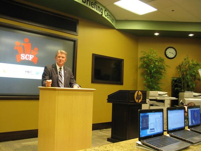 Idaho Gov. Butch Otter speaks at the Hewlett-Packard plant in Boise Tuesday; at right are the laptop computer models H-P plans to sell Idaho schools under a new $180 million contract (Betsy Russell)