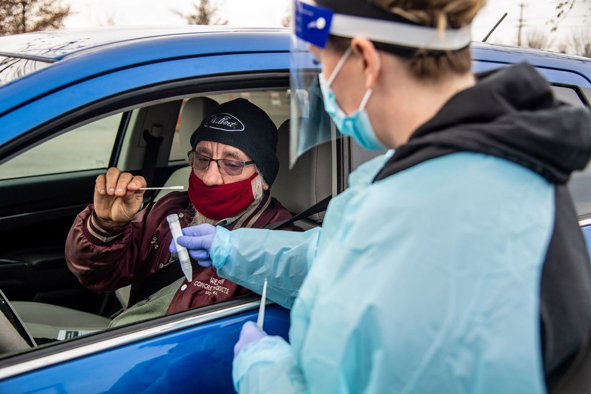 Lauren Emery, a CMA with CHAS Health, performs a COVID-19 test on Nick Trent in the parking lot of the Spokane Arena earlier this month.  (Colin Mulvany/THE SPOKESMAN-REVIEW)