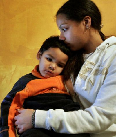 
Tiari Johnson, 16, holds her son, Makhai Kok, 1, in the bedroom she shared with Makhai's father, Samnang Kok, who was  killed Wednesday. 
 (Associated Press / The Spokesman-Review)