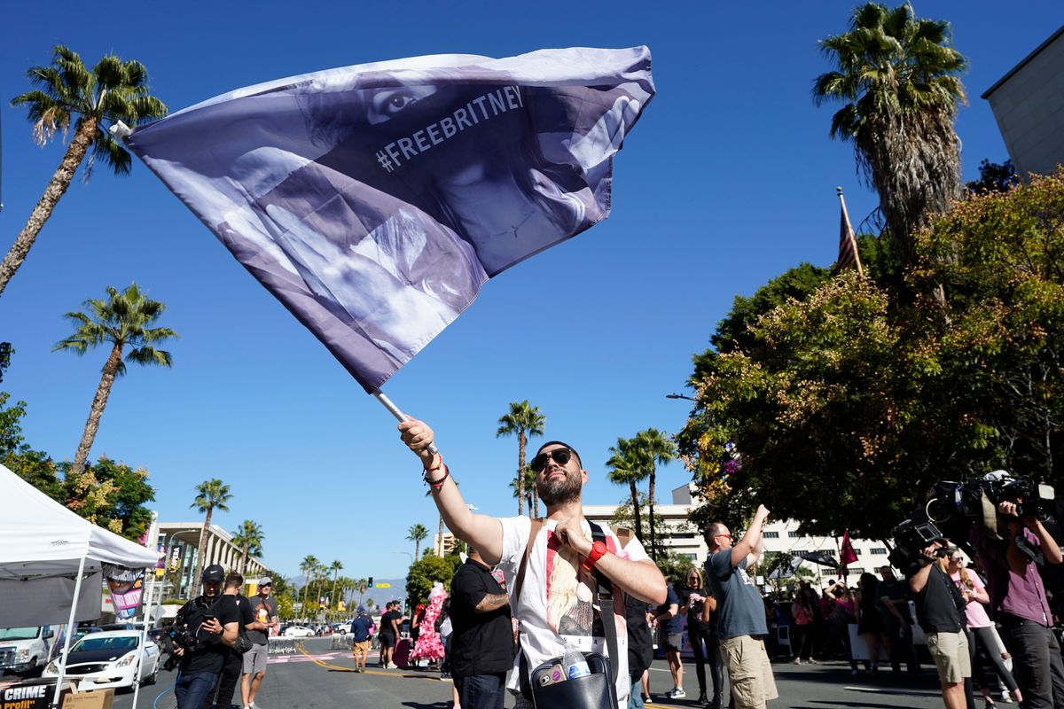 Britney Spears supporter Rafael Lopez, of Tijuana, Mexico, waves a "Free Britney" flag outside a hearing concerning the pop singer's conservatorship at the Stanley Mosk Courthouse, Friday, Nov. 12, 2021, in Los Angeles.  (Chris Pizzello)