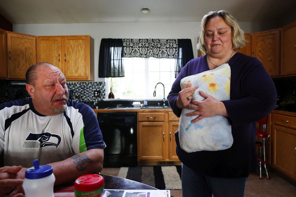 Karen Pszonka holds a pillow made from a blanket that belonged to her grandson Wyatt in her Marysville, Wash., home on March 5, 2015. She and Tom Pszonka, left, are the parents of Katie Ruthven, who perished in the Oso mudslide along with her husband, Shane, their two sons Wyatt and Hunter, and her in-laws, JuDee and Lou Vandenburg. (Mark Harrison / Seattle Times)