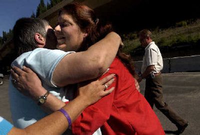 
Sue Boren, a graveyard-shift clerk at Wallace Super-Stop Conoco, gets a few hugs from fellow residents of Wallace after the press conference on Wednesday morning. Boren spotted John Rollins Tuggle in the Conoco just after midnight Wednesday when he asked for a pack of hot dogs. She called 911, and Tuggle was arrested shortly thereafter.
 (The Spokesman-Review)