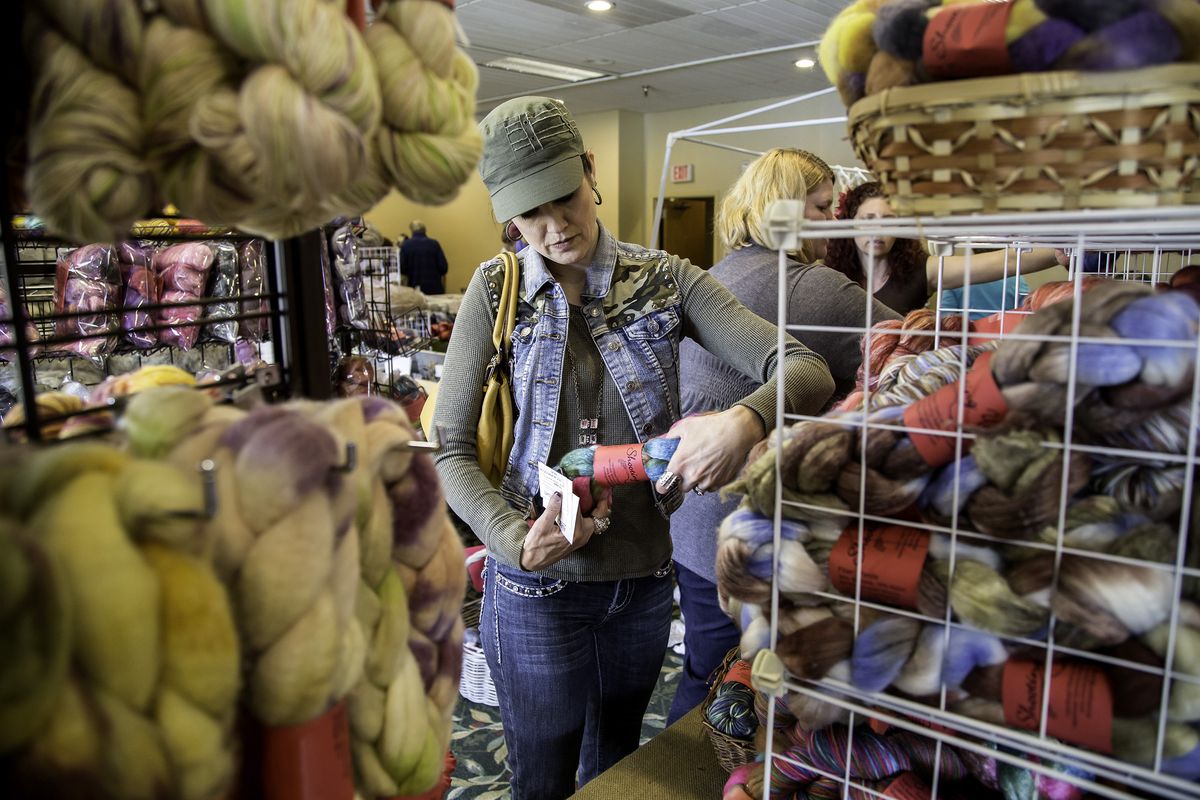 Valerie Hill looks for just the right color and fiber content while shopping Saturday morning at the Log Cabin Spinner’s Guild’s 25th annual Spin-In at the Red Lion Templin’s Hotel in Post Falls. (BRUCE TWITCHELL)