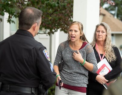 Crystal Jenkins, center, and mother Debbie Novak confront Spokane police Officer Terry Preuninger in 2019, demanding to be allowed into a news conference where officials gave their official account of the shooting of David Novak, the brother and son of the women.  (JESSE TINSLEY)