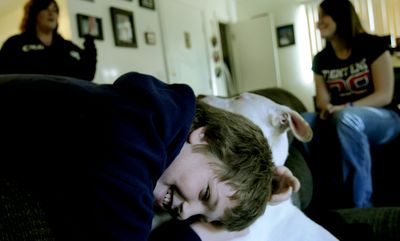 Jasen Petersen, 10, plays with the family dog, Malachie, with his mother, Kristy Petersen, left, and his sister, Raquelle Proffitt, 15. The family recently moved into this apartment after living in motels.  (Kathy Plonka / The Spokesman-Review)