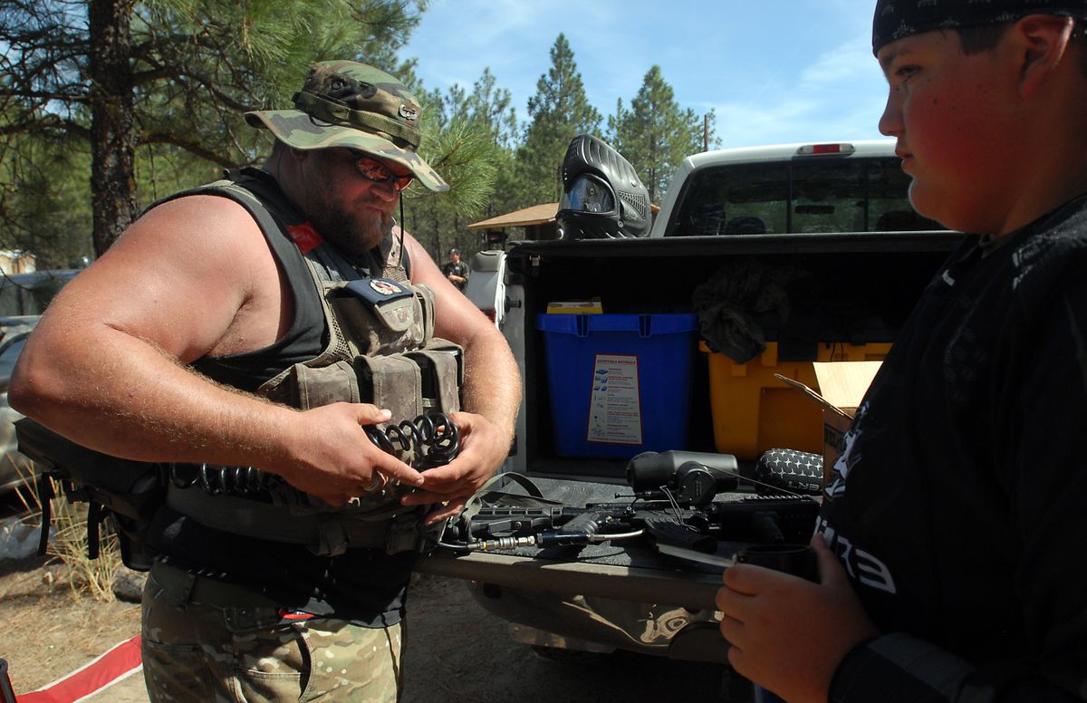 Chris Frank and his son, Tyler Whitehead, right, gear up for the second round of games during Mortar Wars. Frank, who played football for Washington State in the early 1990s, says he enjoys the workout as well as the competition involved in paintball. (Jesse Tinsley / The Spokesman-Review)