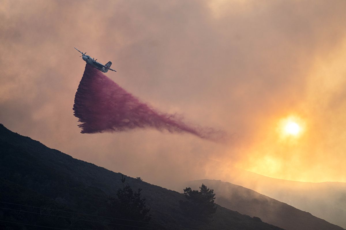 An aircraft distributes fire retardant and water to support Big Sur Fire and CalFire firefighters from nearby areas in battling the Colorado Fire in Big Sur, Calif., on Jan. 22, 2022. (MUST CREDIT: Washington Post photo by Melina Mara)  (Melina Mara/The Washington Post)