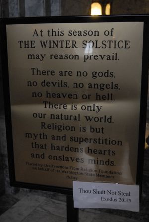This winter solstice sign erected at Washington's state capitol by an atheist group from Wisconsin was briefly stolen. After state police recovered it, someone attached a "thou shalt not steal" sign to it.  (Rich Roesler / The Spokesman-Review)
