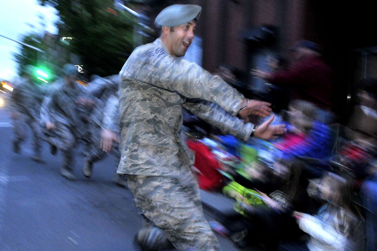 Students from the Air Force survival school at Fairchild break ranks for handshakes and high-fives with spectators. (Jesse Tinsley)