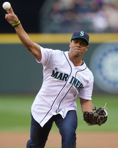 Russell Wilson throws out ceremonial first pitch before a Mariners game in Seattle. (Associated Press)