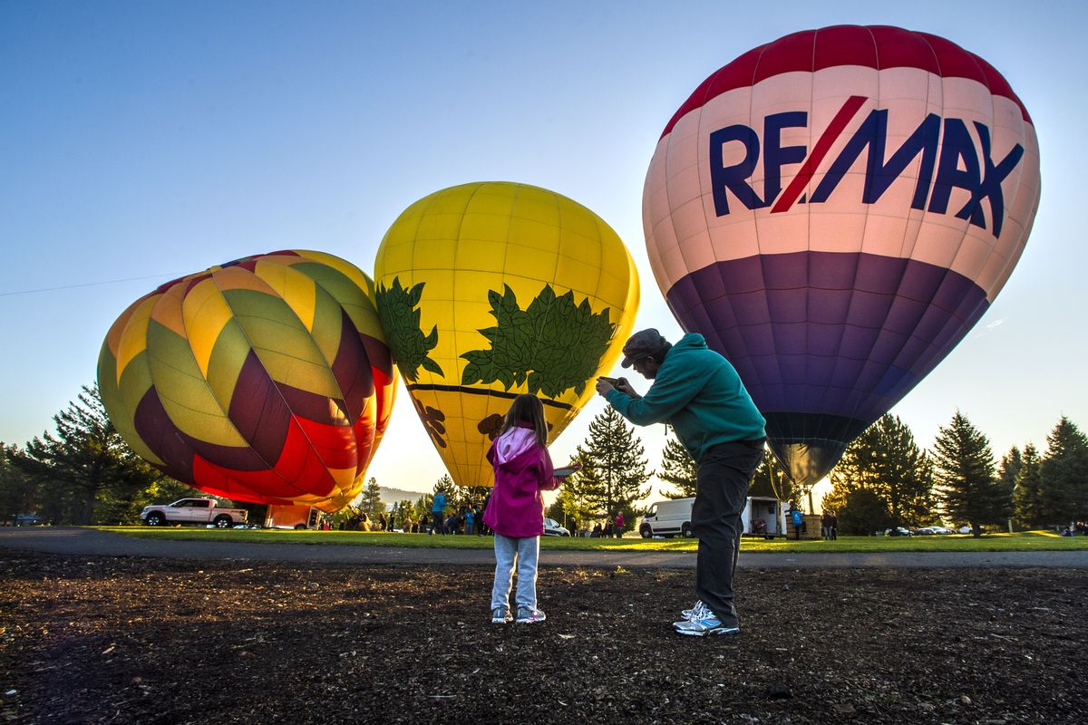 Cell phone pictures are taken at dawn of the Lighten Up, Spuds and RE/MAX balloons before lifting off for the Balloon Over Valleyfest on Sept. 24, 2017, at CenterPlace Regional Event Center.  (DAN PELLE)