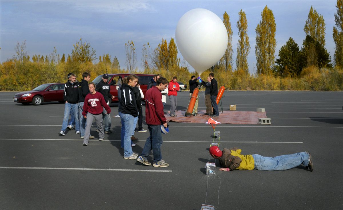 Whitworth physics students make last-second checks on their instrumentation pods attached to a weather balloon they are about to launch from Potholes State Park south of Moses Lake on Thursday. (Christopher Anderson / The Spokesman-Review)