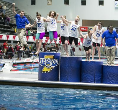 Carmel High School swimmers and coaches jump into the water after winning their 30th straight state title, a national record in any sport. (Robert Scheer / Indianapolis Star)