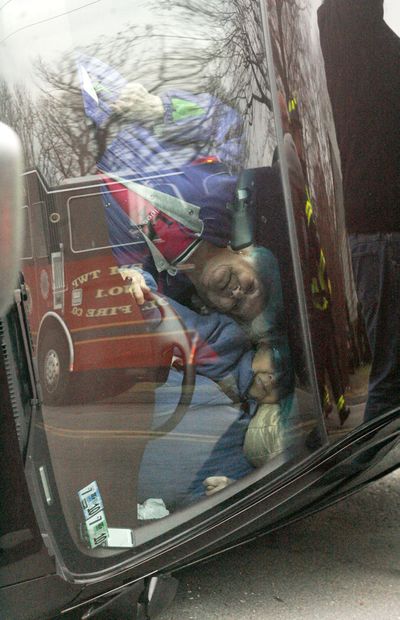 Passenger Philomena Fischetti, top, hangs from her seat belt while leaning on Kathleen Futoma as the women look through the front windshield of Futoma's car near Berwick, Pa., Wednesday, Jan. 20, 2010. They are waiting for rescue personnel to free them from the vehicle, which came to rest on it's side after Futoma struck a trailer hauling cars parked along Route 11. The two were taken to the hospital to be checked out after the crash but both were uninjured. (Jimmy May / Bloomsburg Press Enterprise)
