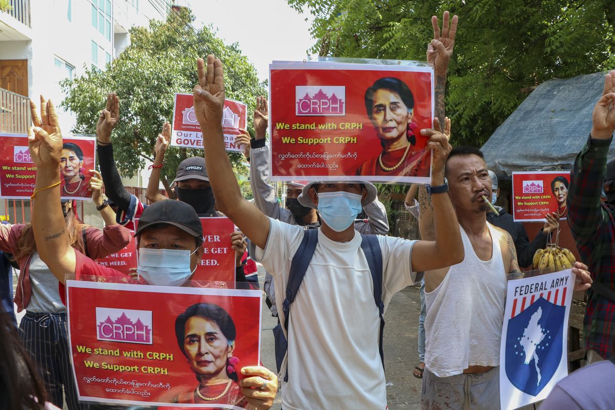 Anti-coup protesters flash the three-fingered symbol of resistance while holding slogans bearing pictures of deposed leader Aung San Suu Kyi during a demonstration in Yangon, Myanmar on Wednesday April 7, 2021. Threats of lethal violence and arrests of protesters have failed to suppress daily demonstrations across Myanmar demanding the military step down and reinstate the democratically elected government.  (STR)