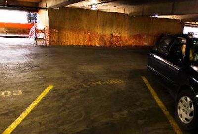 
Heather Unher gets into a car on the fifth floor of the River Park Square parking garage on Sunday across from the barricades put up after Jo Savage's car crashed through a concrete barrier. 
 (Kathryn Stevens / The Spokesman-Review)