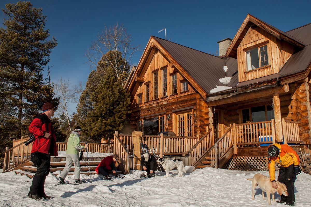 Snowshoe adjustments are necessary in front of the lodge at Siwash Lake Ranch, British Columbia.