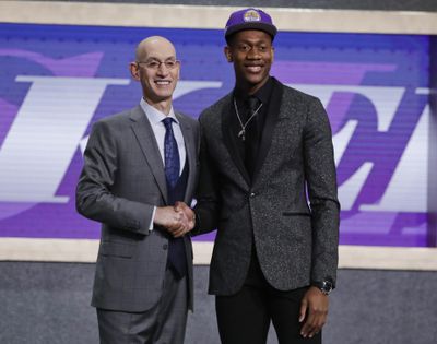 In this Thursday, June 20, 2019 photo, Virginia’s De’Andre Hunter, right, is greeted by NBA Commissioner Adam Silver after being selected with the fourth pick overall by the Los Angeles Lakers during the NBA basketball draft in New York. Hunter went No. 4 overall, taken by the Los Angeles Lakers. His rights had been traded twice, first to New Orleans as part of the Anthony Davis deal, then to Atlanta. But since neither of those trades could be closed before July 6, Hunter wore a Lakers cap on stage. Silver wants the hat game fixed. (Julio Cortez / Associated Press)