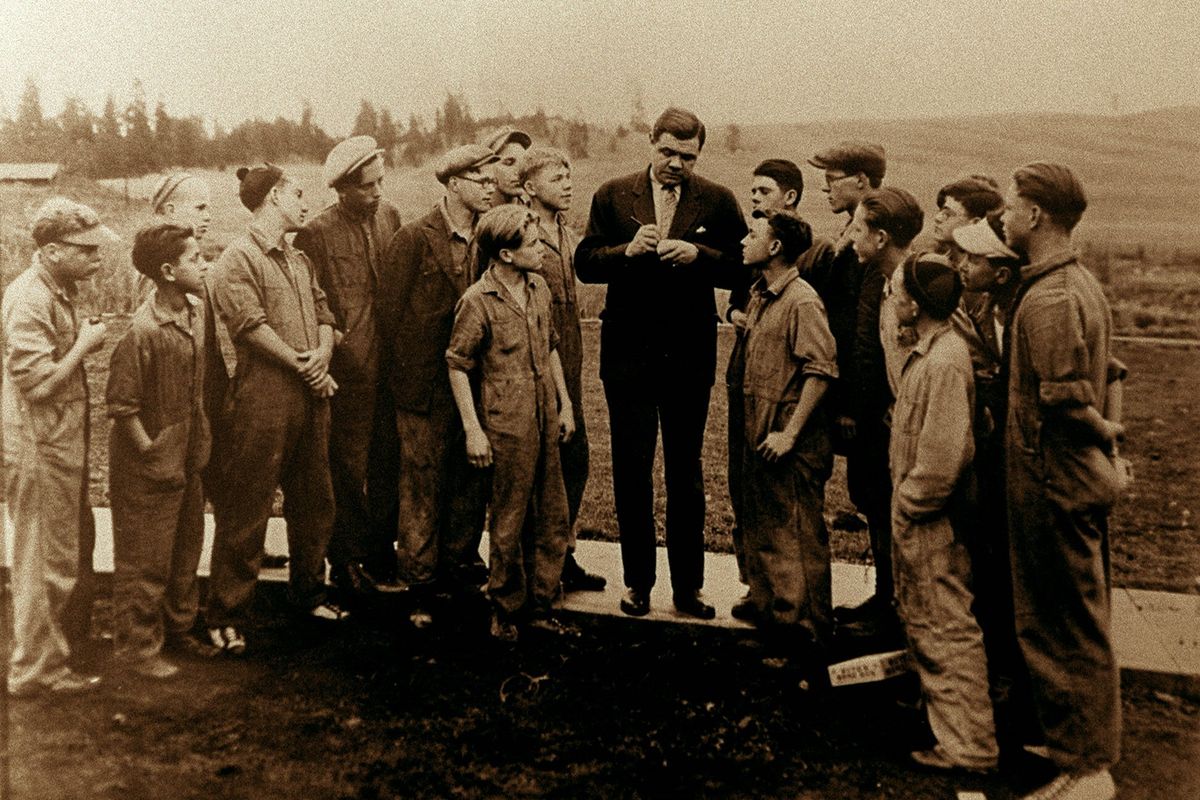 Babe Ruth, who was known as “America’s most famous orphan,” signs baseballs for children at the Hutton Settlement in 1924.  (The Spokesman-Review photo archive)