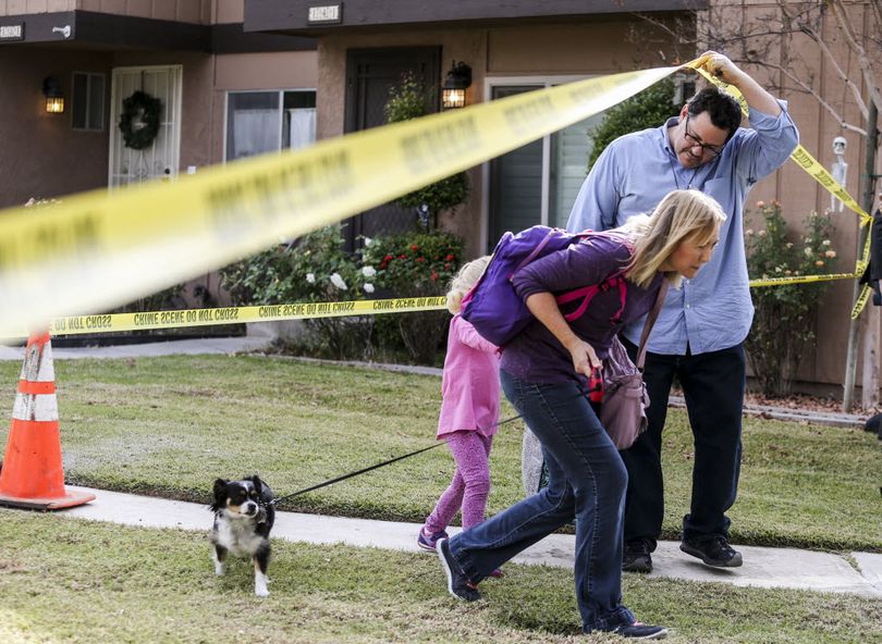 People leave their home in the neighborhood near a home being investigated in connection to the shootings in San Bernardino in Redlands, Calif., today. A heavily armed man and woman opened fire Wednesday on a holiday banquet for his co-workers, killing multiple people and seriously wounding others in a precision assault, authorities said. Hours later, they died in a shootout with police. (AP Photo/Ringo H.W. Chiu)