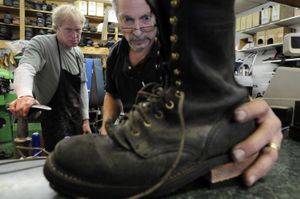 Shoe-repair specialists Steve Weigand, left, and Greg Ressa eyeball the heel angle on a logging boot undergoing a resole at Ressa Shoe Repair in Spokane on Dec. 24. Ressa can make minor repairs and do major rebuilds on most types of shoes.  (Jesse Tinsley / The Spokesman-Review)