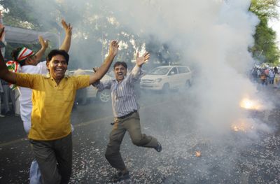 A Congress party supporter dances in celebration as fireworks go off outside the Congress party President Sonia Gandhi’s residence in New Delhi, India, Saturday.  (Associated Press / The Spokesman-Review)