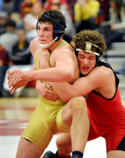 Ferris’ Russell Stinson, right, hangs on to Mead’s Shane Kuykendall to win the 189-pound title during Saturday’s regional 4A meet at Ferris. (Jesse Tinsley)