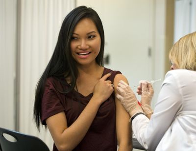 Hanh To, a first-year pharmacy student at Washington State University, prepares herself for a flu shot from second-year pharmacy student MaryAnne Gellings on Wednesday, Oct. 7, 2015, at the school’s South Campus Facility in Spokane. Some 32 WSU nutrition and exercise physiology students organized the 9th annual health fair that included over 560 free flu shots, cholesterol and fitness testing, body composition analysis and 30 vendors for the one-day event. “I’m not afraid of shots, but I can’t see blood. Not even my own. That’s why I went into pharmacy.” says To. (Dan Pelle / The Spokesman-Review)