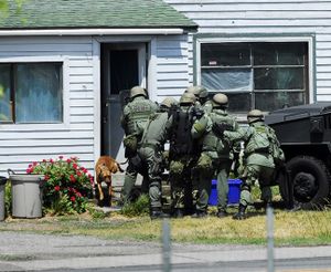 A dogs runs out the front door of a house at 11423 E. Broadway Ave. after the Spokane County Sheriff's Office SWAT team kicked in the door Monday afternoon, June 8, 2009. Spokane Valley police were engaged in a standoff with a man they believed was armed inside the Spokane Valley home. (J. Bart Rayniak / The Spokesman-Review)