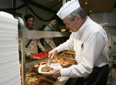 
Secretary of Defense Donald H. Rumsfeld helps serve Christmas dinner to soldiers in Mosul, Iraq, on Saturday as he wraps up a five-day tour of the Middle East. 
 (Associated Press / The Spokesman-Review)