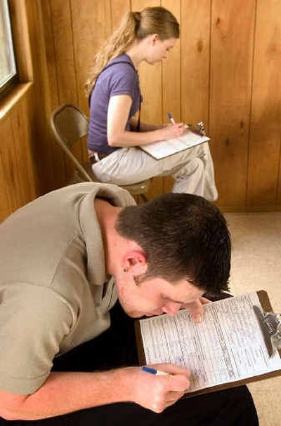 
College students Brandon Nelson, 19, bottom, and Devi  Walls, 22, fill out job applications on Thursday for server positions at the new Anthony's Fresh Fish Restaurant overlooking the Spokane Falls.
 (Colin Mulvany / The Spokesman-Review)