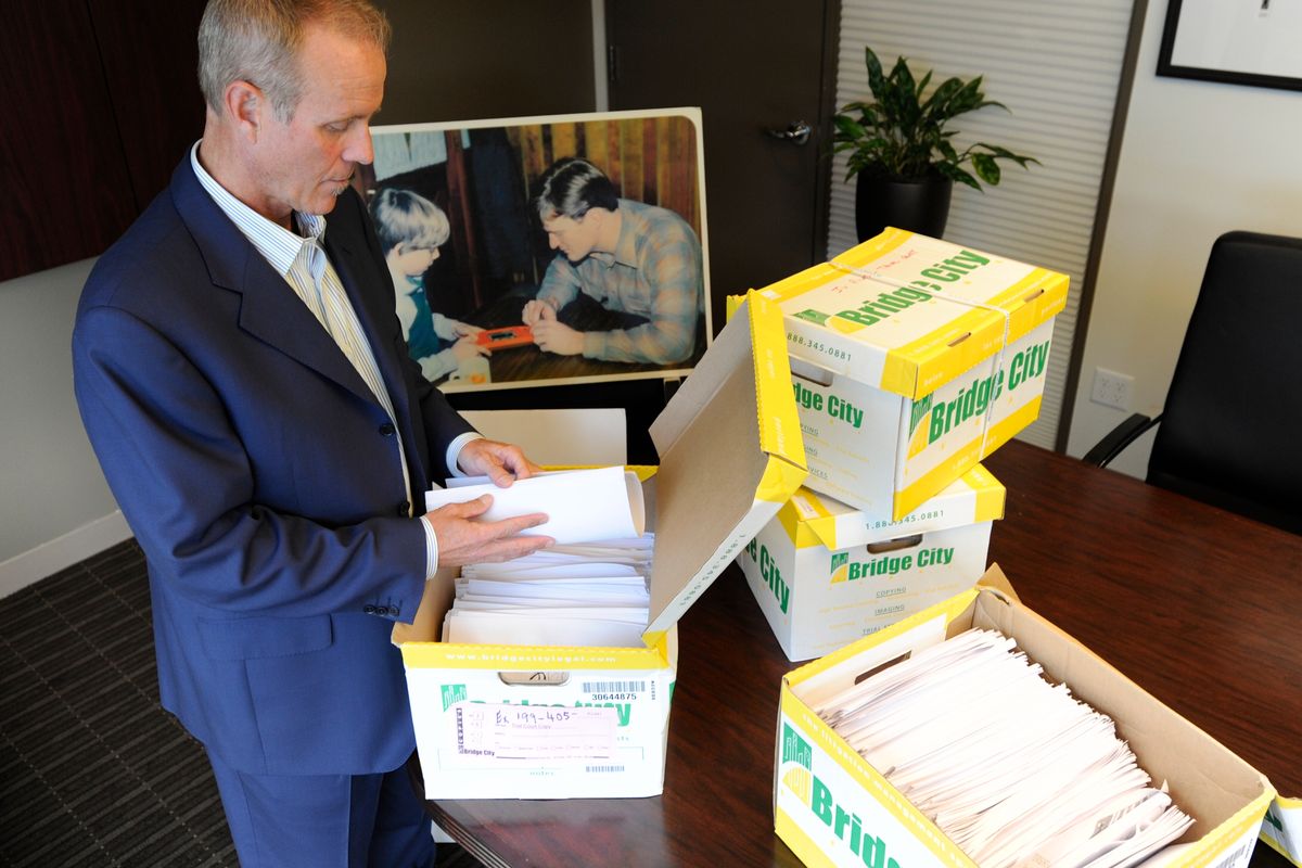 In a Tuesday, Oct., 16, 2012 photo, Portland attorney Kelly Clark examines some of the 14,500 pages of previously confidential documents created by the  Boy Scouts of America concerning child sexual abuse within the organization, in preparation for releasing the documents Thursday, Oct. 18, as he stands in his office in Portland, Ore. The Boy Scouts of America fought to keep those files confidential. (Greg Wahl-stephens / Fr29287 Ap)