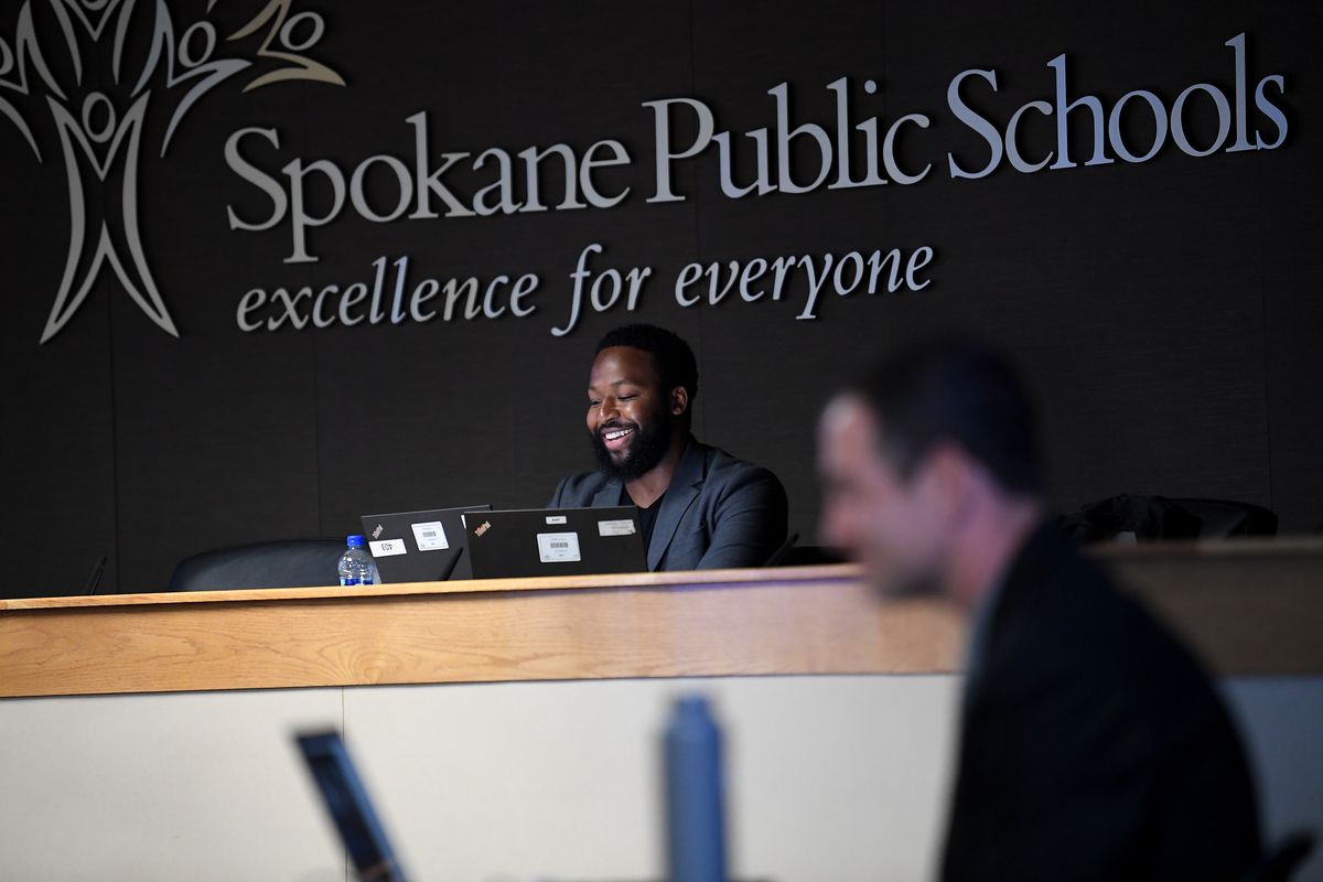 Jerrall Haynes, left, President of the Spokane Public School Board, smiles after swearing in Dr. Adam Swinyard, right, Spokane Public Schools