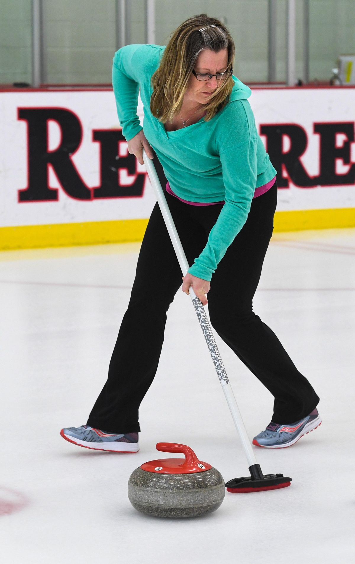 Reporter Angela Schneider tries her hand at sweeping during a curling demonstration, Wednesday, Jan. 28, 2020, at the EWU Recreation Center in Cheney, Wash. (Dan Pelle / The Spokesman-Review)
