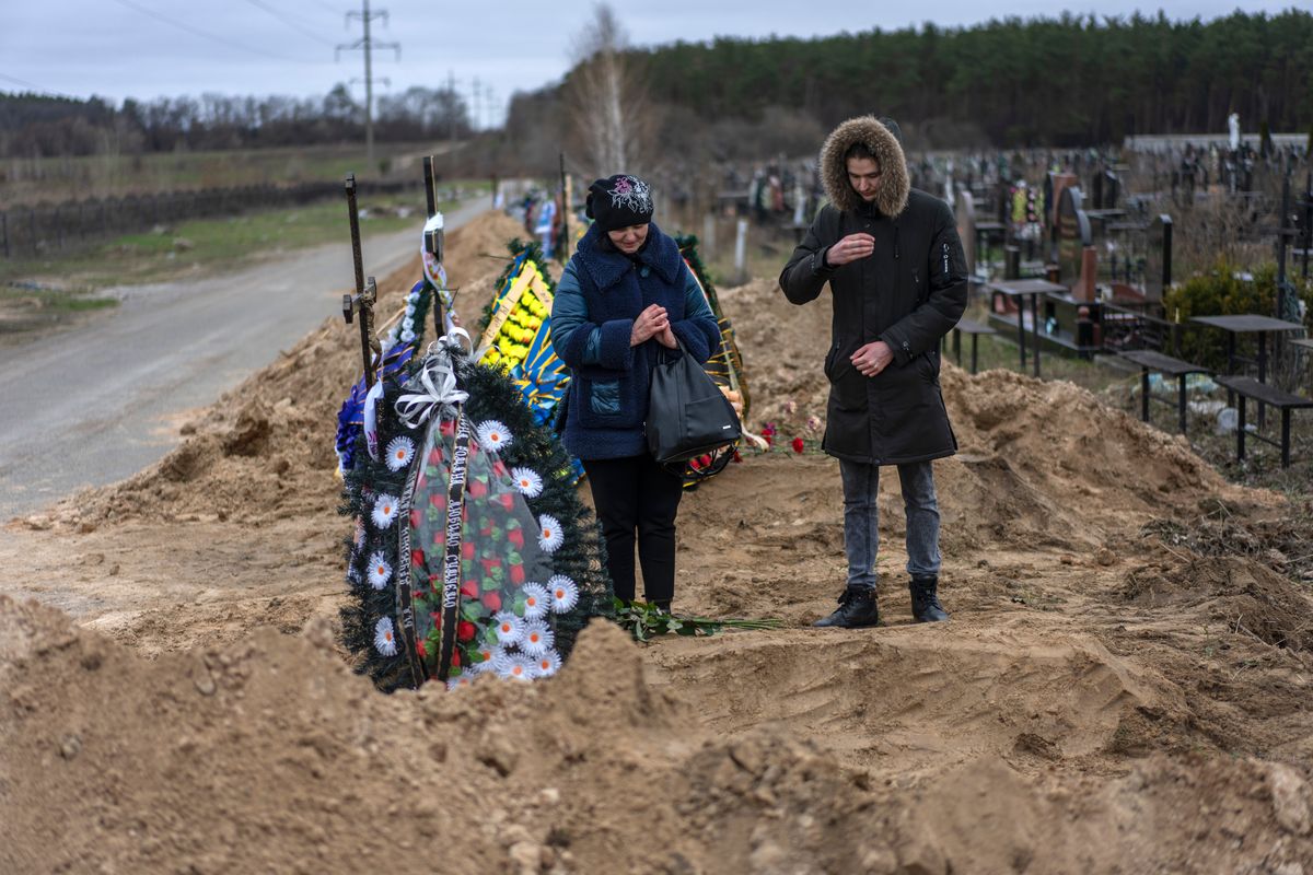 Natalya Verbova and her son, Roman Verbovyi, attend the funeral of her husband, Andriy Verbovyi, on Wednesday after he was killed by Russian soldiers in the outskirts of Kyiv, Ukraine.  (Rodrigo Abd)