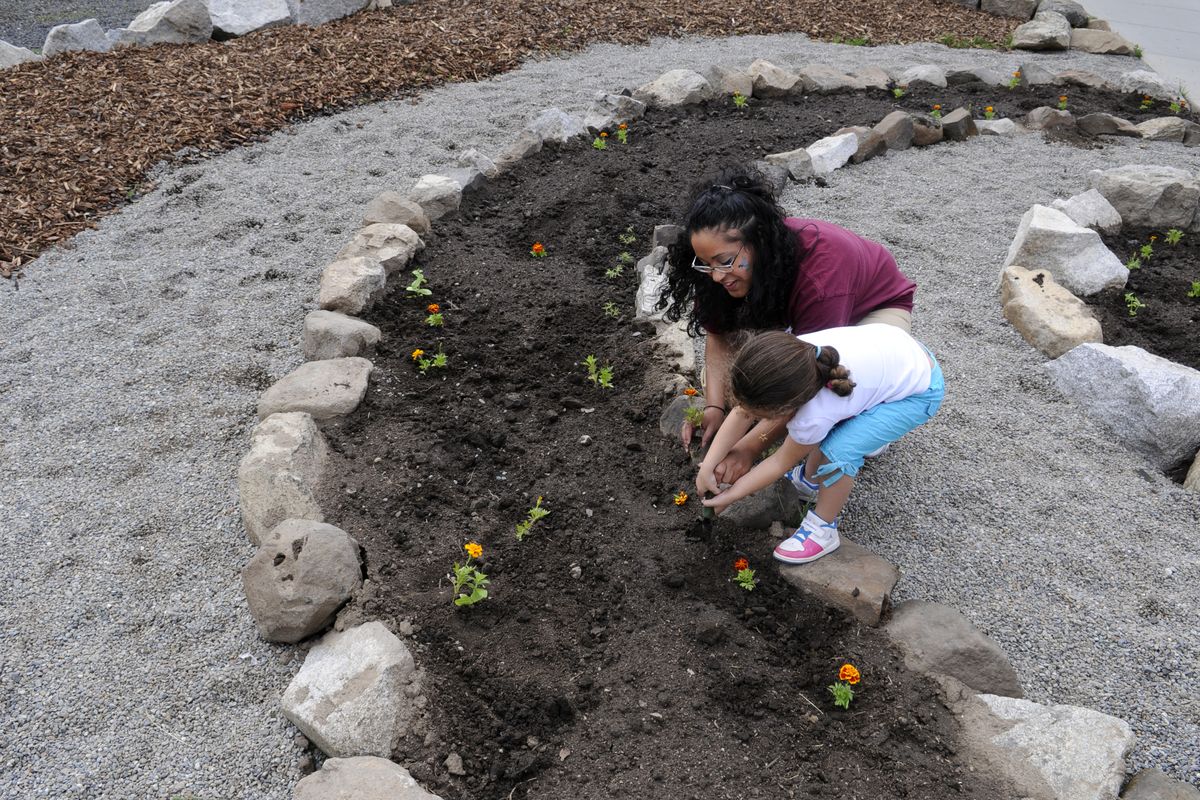 Chanel Trim, 25, and her daughter, Aniah. 4, plant a marigold in the Pine Lodge Corrections Center, May 1, 2010 in Medical Lake, Wa., during the corrections center