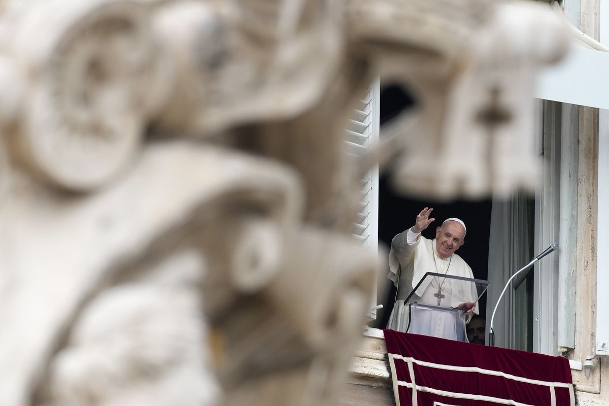 Pope Francis waves as he arrives for the Angelus noon prayer from the window of his studio overlooking St.Peter