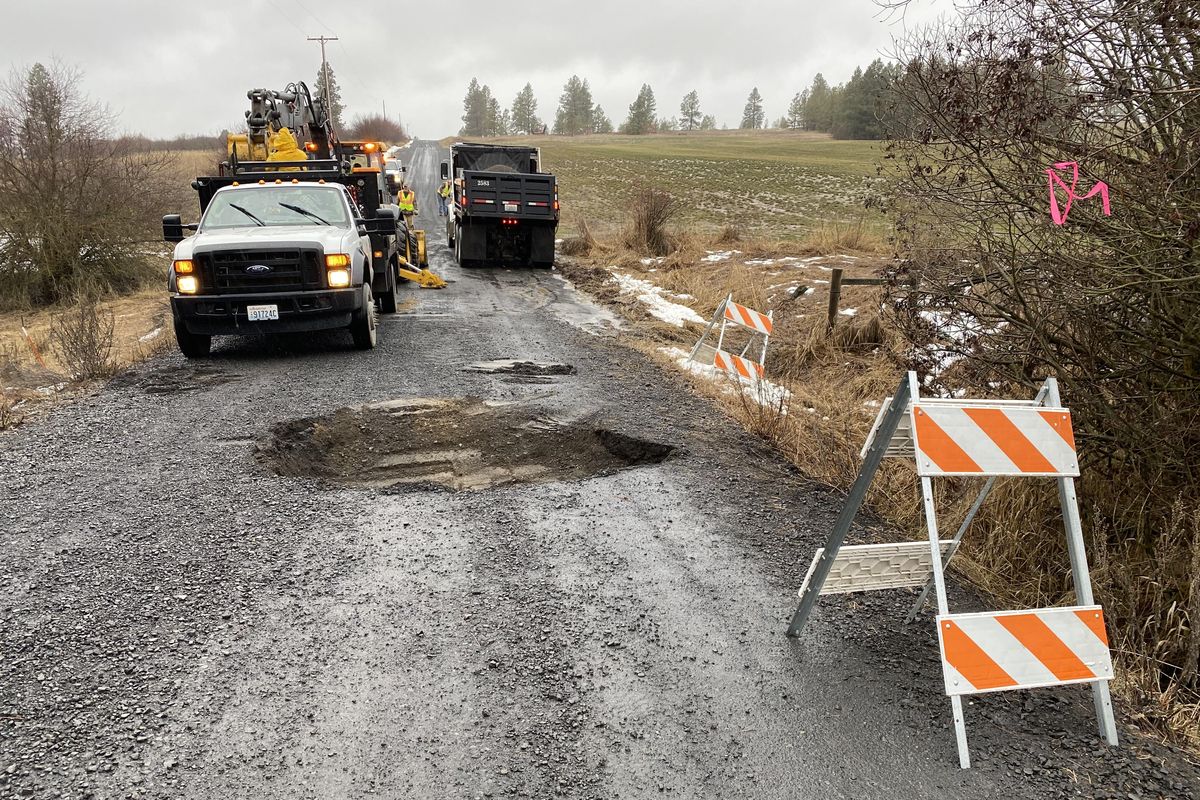 A sink hole closed East Conner Road just west of South Sands Road near Valleyford as Spokane County Public Works crews dug up part of the roadway and filled the hole. (Jared Brown, SR)