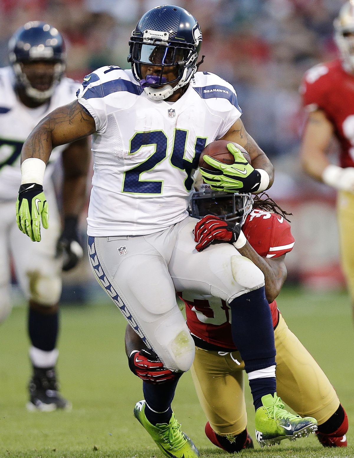 Seahawks RB Marshawn Lynch rushes past 49ers safety Dashon Goldson during the second quarter. Lynch rushed for 103 yards on 19 carries and caught one pass. (Associated Press)
