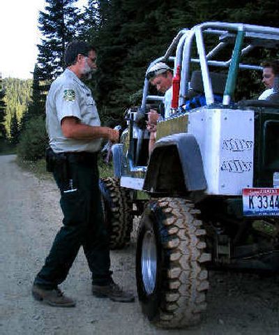 
Forest Service law officer Ron Nelson talks with Lee Kirk of Rathdrum in the national forest on a recent Saturday. Just moments before, he spotted this Jeep emerging from the North Fork of the Coeur d'Alene River. Signs made it clear such off-trail travel was illegal. Kirk got a $100 citation.
 (James Hagengruber / The Spokesman-Review)