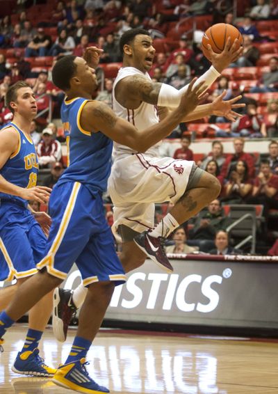 WSU’s DaVonte Lacy, right, shoots after getting past UCLA’s Norman Powell, center, and David Wear. (Associated Press)