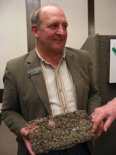 Idaho Rep. Eric Anderson, R-Priest Lake, shows an Idaho license plate that was suspended in the waters of Lake Mead for nine months; it's now encrusted with invasive quagga mussels. Anderson displayed the plate during and after his address to the Idaho Environmental Forum in Boise on Tuesday. (Betsy Russell)