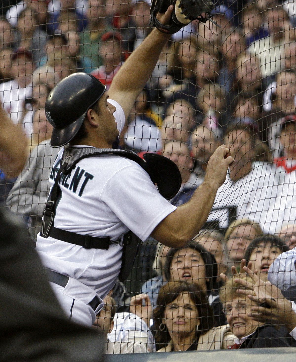 M’s Jeff Clement runs into the netting behind home plate and is injured chasing a pop foul.  (Associated Press / The Spokesman-Review)