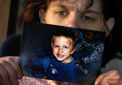 
Kenda Bradford holds a photograph of her biological son Tyler DeLeon,    who died of severe dehydration  at age 7.  Bradford says she wasn't consulted before  the offer of a plea deal that let Tyler's foster mother, Carole DeLeon, avoid a murder trial. 
 (File / The Spokesman-Review)