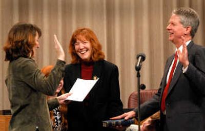 
Betsy Rush, center, cracks up as her husband, Richard Rush, right, corrects City Clerk Terri Pfister, left, during his oath of office on Thursday  at Spokane City Hall. Pfister incorrectly identified the office for which Rush was elected. Also on stage were the Rush children, Madeleine, 11, and Jasper, 7. 
 (Jesse Tinsley / The Spokesman-Review)
