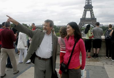 Christian Ragil, left, guides Ju Young Gam of South Korea, as they tour the Trocadero plaza near the Eiffel Tower.  (Associated Press / The Spokesman-Review)