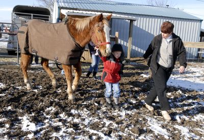 Mozelle Callihan leads 5-year old Jameson Wasson and Dusty, the 27-year-old horse, into the pasture behind her house  Dec. 16. (File / The Spokesman-Review)