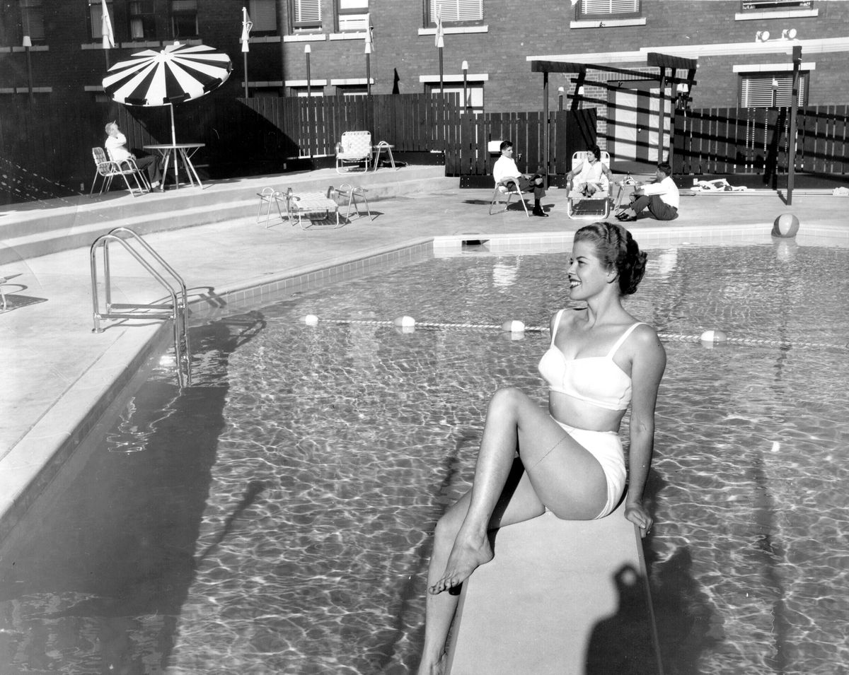 Gail Shatwell of Spokane takes a sneak-peek at the new Davenport Hotel eight-sided pool, which was the focal point of an "aqua terrace and lounge."  More than 500 civic and business leaders, newspaper, radio and television representatives were invited to the dedication in the summer of 1957 where a fashion show, water show and diving displays were on the agenda. (Photo Archive)