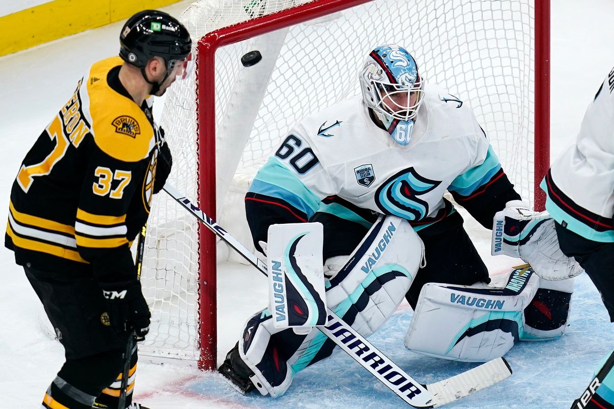 Seattle Kraken goaltender Chris Driedger (60) looks for the shot as the puck sails over his shoulder for a goal by Boston Bruins right wing David Pastrnak during the second period of an NHL hockey game, Tuesday, Feb. 1, 2022, in Boston. At left is Boston Bruins center Patrice Bergeron (37).  (Charles Krupa)